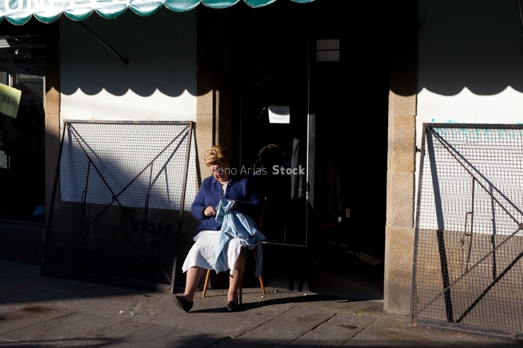 Muller cosendo nas rúas de Santiago de Compostela, Galicia